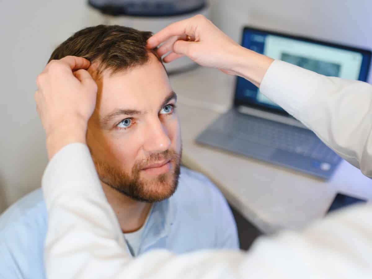 a trichologist examines the hair of a man who begins alopecia. consultation with a dermatologist. hair loss, alopecia, pruritus
