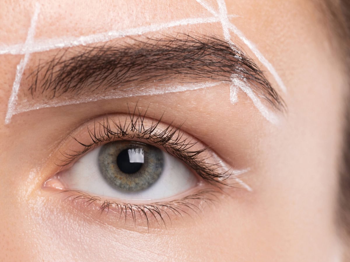 female face during professional eyebrow mapping procedure before