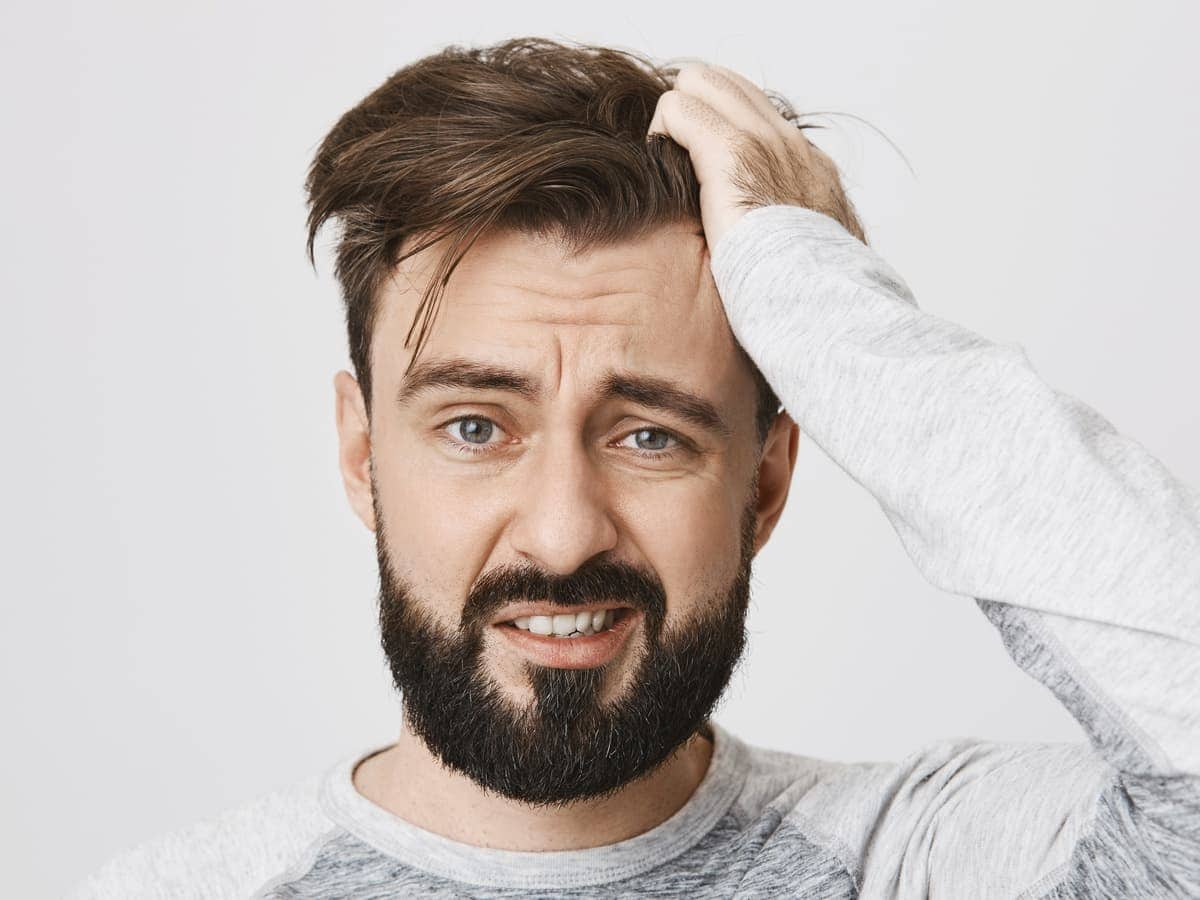 frustrated man with hand in hair indoors 2026 03 09 23 13 51 utc (1)