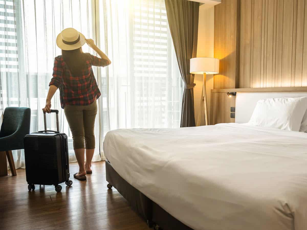 happiness traveler woman standing with baggage in bedroom