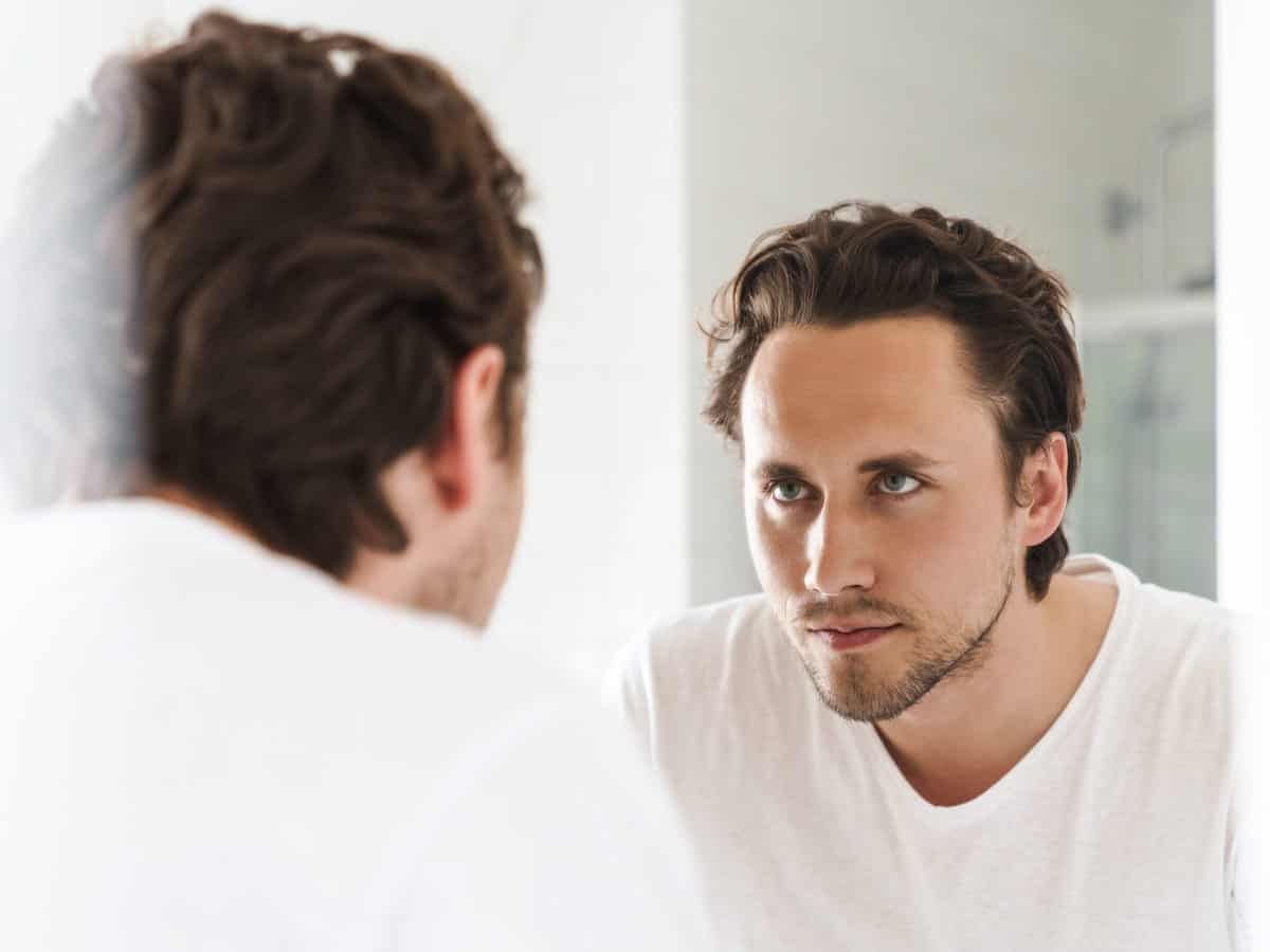 Hair Transplant Duration to Expect on the Day man looks at reflection in bathroom mirror 2026 03 19 04 26 40 utc