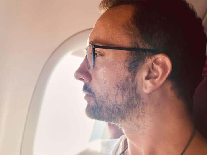 man looks out airplane window during flight 2026 04 13 02 34 22 utc