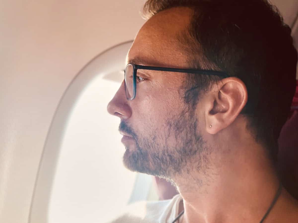 man looks out airplane window during flight 2026 04 13 02 34 22 utc