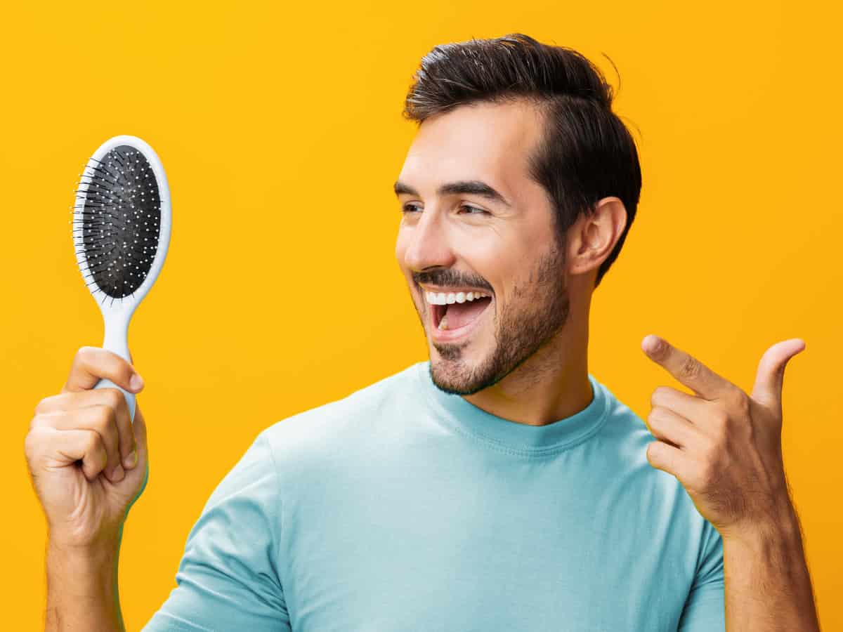 Master Hair Transplant Aftercare to Protect Your Results man studio barber hair handsome brushing loss hair comb portrait hairstyle face