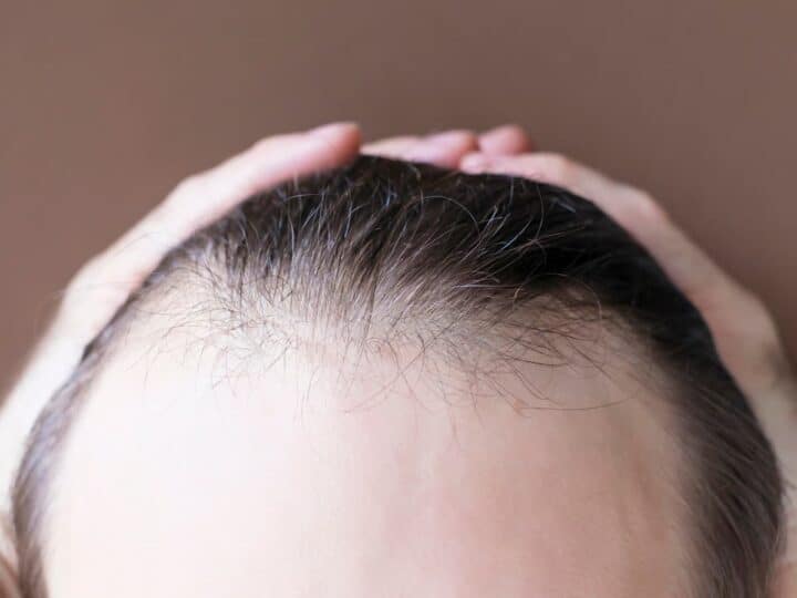 man touching her hair close up on brown background 2026 03 17 06 53 02 utc (1)