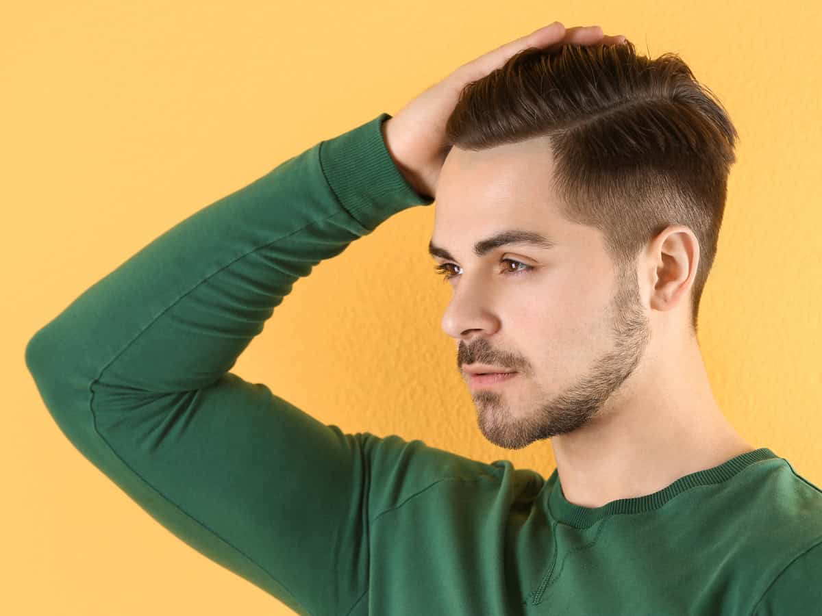 portrait of young man with beautiful hair on color background