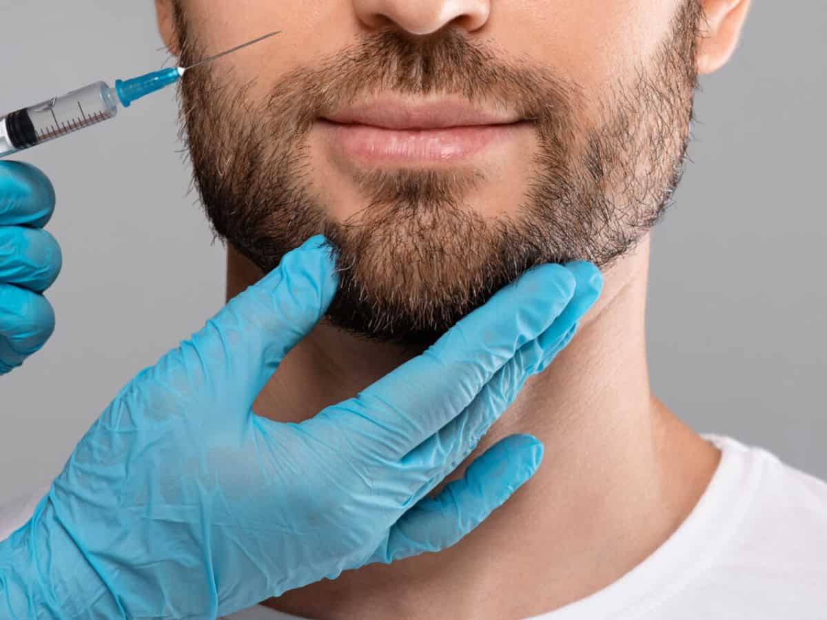 Beard Transplant Cost in Thailand - What to Expect Before You Go unrecognizable bearded man getting lips filler in beauty salon, panorama